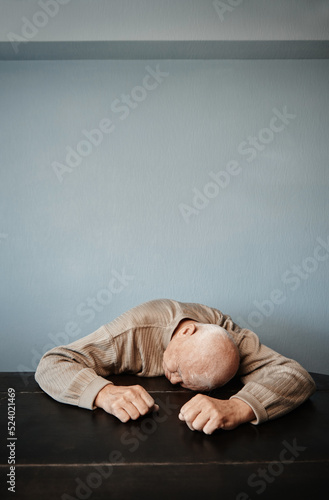 Exhausted senior man sleeping on a table