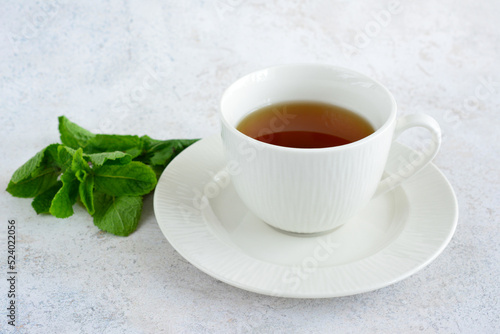 mint tea in white cup with saucer, close-up