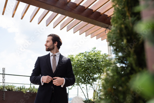 Wallpaper Mural Side view of groom in formal wear looking away on terrace. Torontodigital.ca