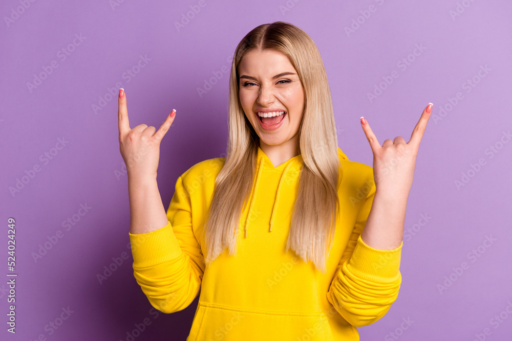 Photo of young excited woman show fingers harsh horns rock symbol isolated over violet color background