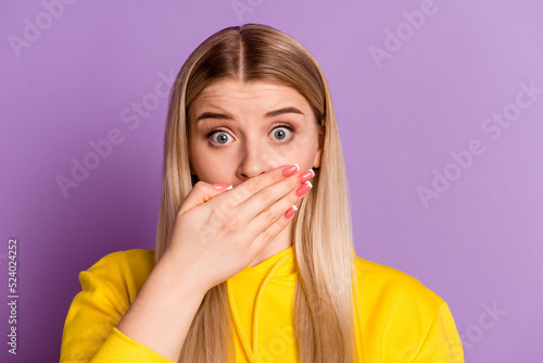 Photo of young girl cover mouth hand oops problem tell secret information isolated over violet color background photo