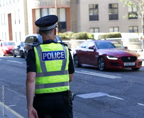 Police officer on duty on a city centre street during special event. 