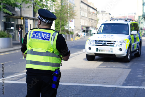 Police officer on duty on a city centre street during special event. 