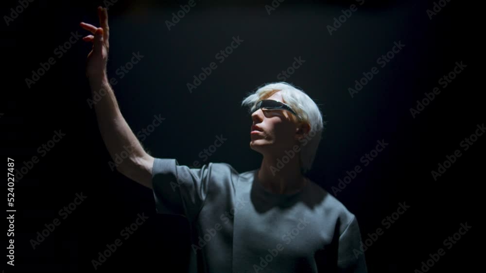 Man using vr headset in dark room light. Futuristic player touching invisible Man using vr headset in dark room light. Futuristic player touching invisible