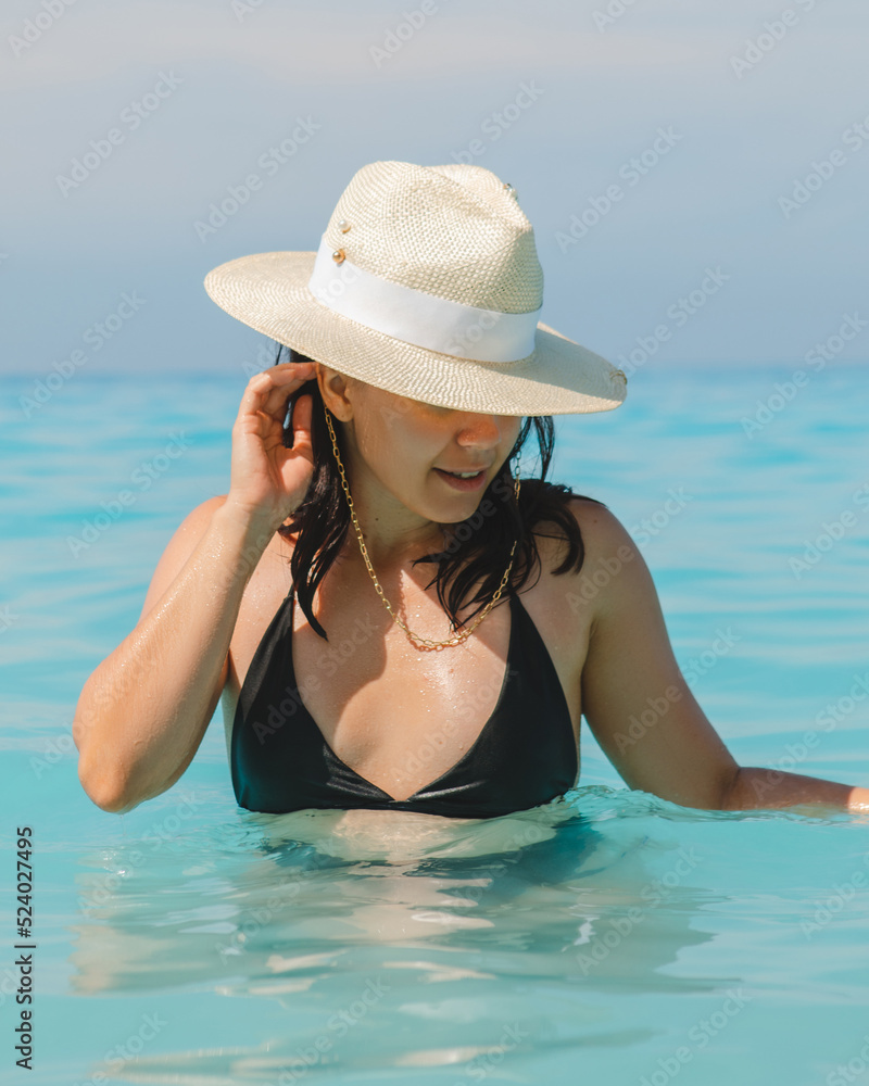 woman in white hat and black swimsuit in blue sea water
