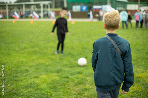 Children play ball on lawn. Schoolchildren on sports ground in summer.