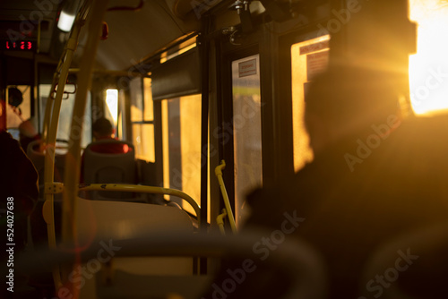 Inside bus is light of sun. People in transport.