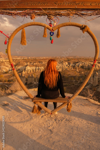 Girl sitting on a swing overlooking a valley