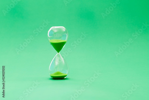 A hourglass on green background