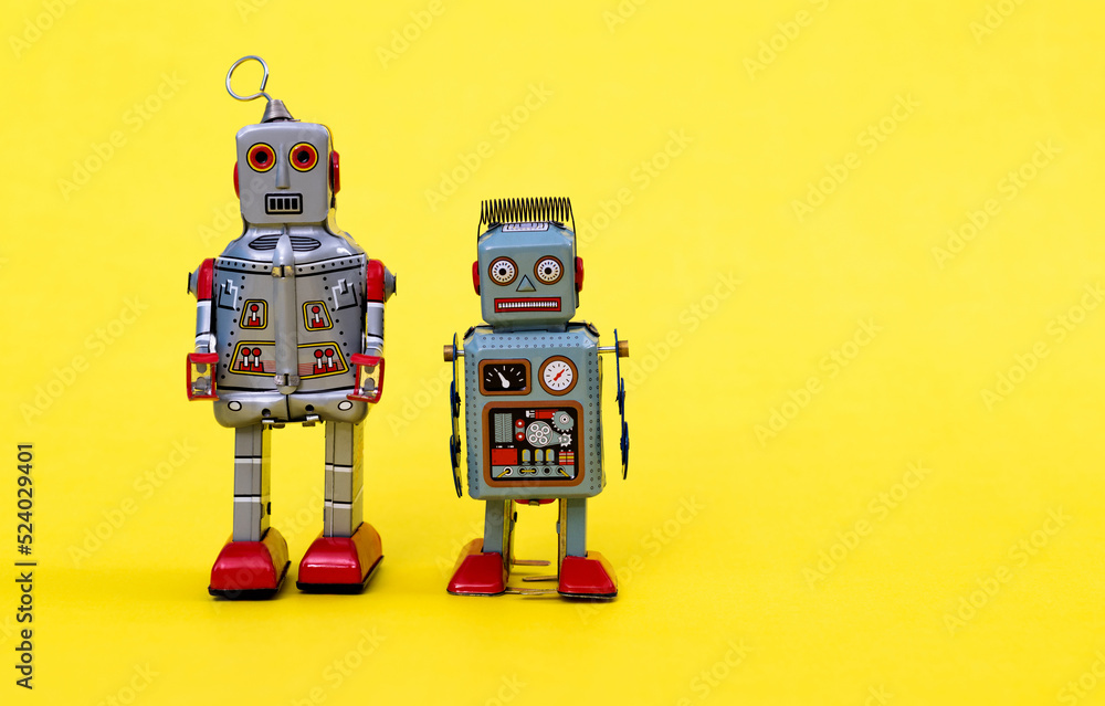 Retro robot toys on yellow background Retro robot toys on yellow background