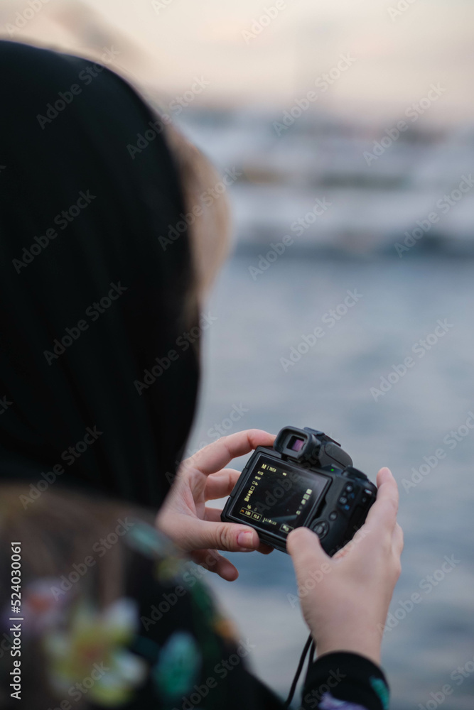 Fototapeta premium woman taking photos of a river with a digital camera