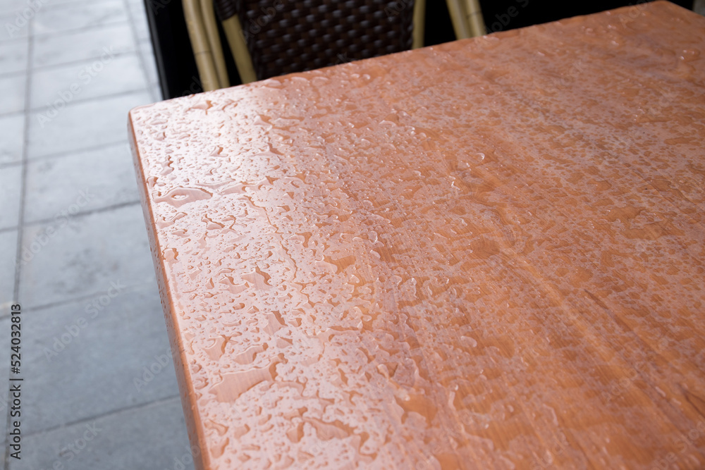 The surface of the table is covered in drops after rain.