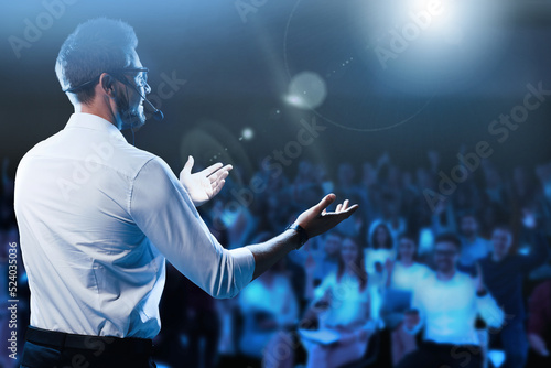 Motivational speaker with headset performing on stage photo