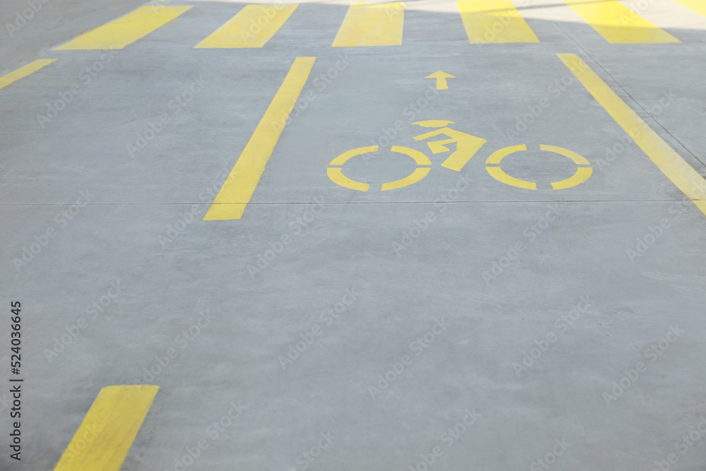 Bike lane with painted yellow bicycle sign and arrow near pedestrian crossing Bike lane with painted yellow bicycle sign and arrow near pedestrian crossing