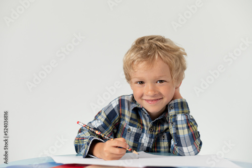 Boy with a pencil sitting at a table, school education