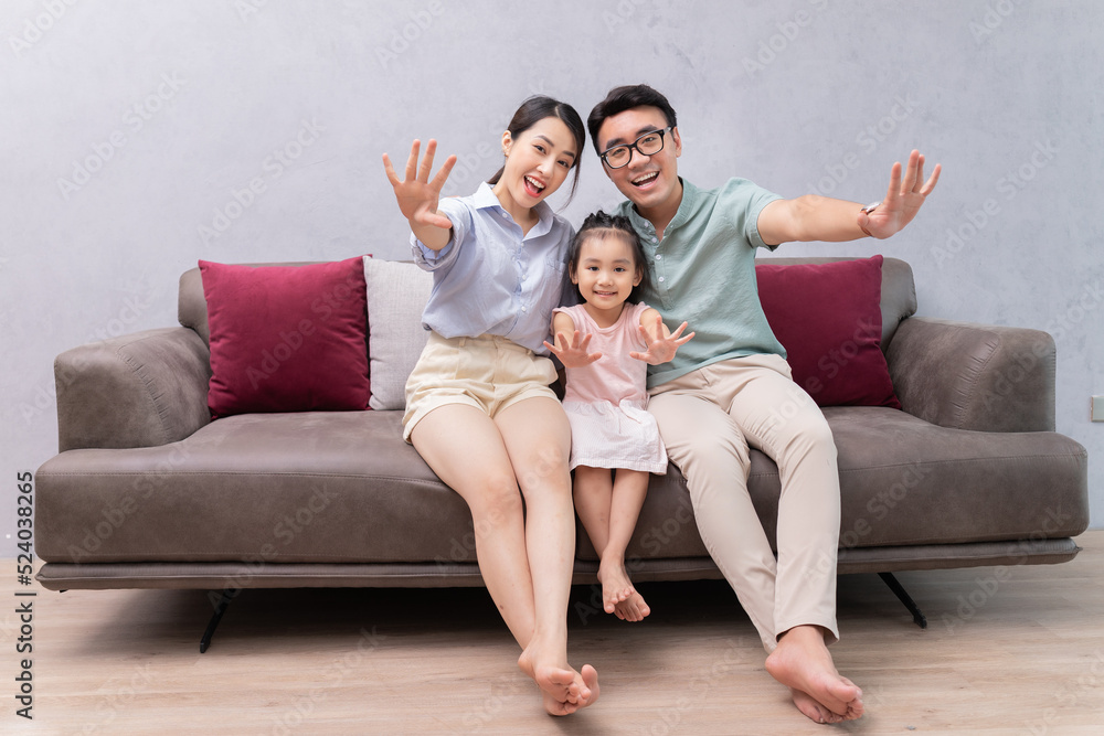 Young Asian family sitting on sofa Young Asian family sitting on sofa