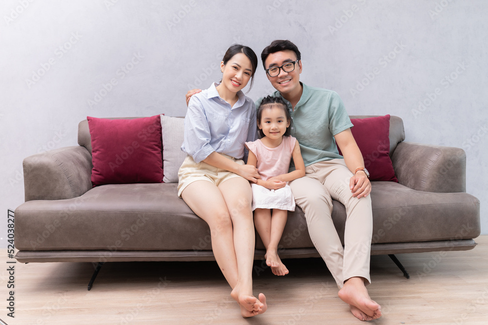 Young Asian family sitting on sofa Young Asian family sitting on sofa