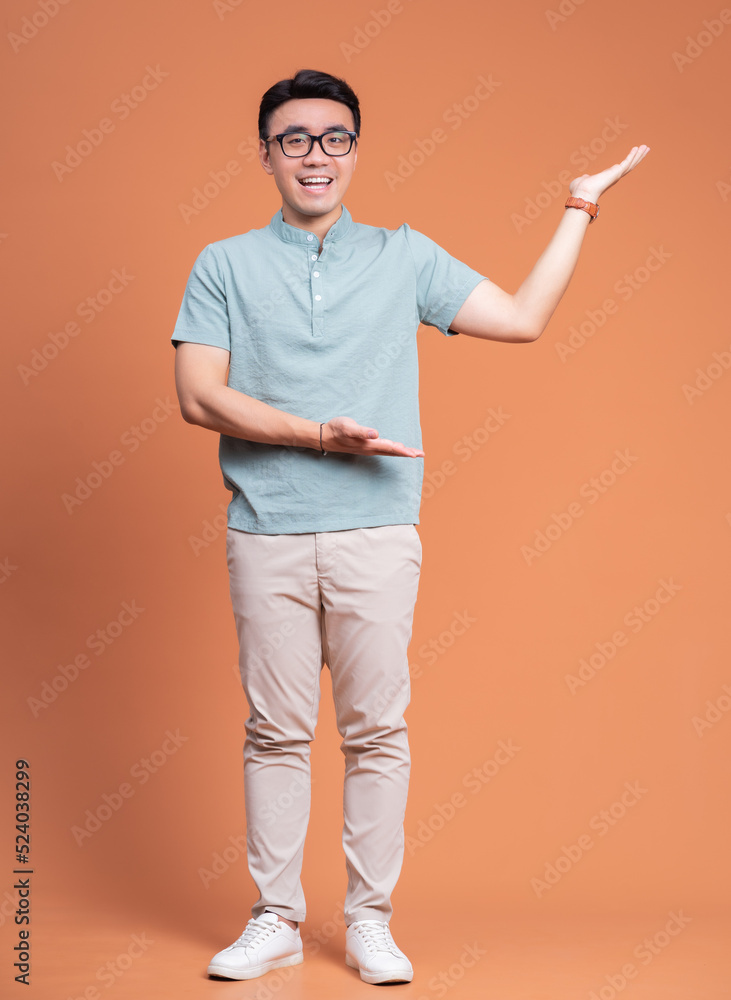 Full length image of young Asian man standing on backgound Full length image of young Asian man standing on backgound