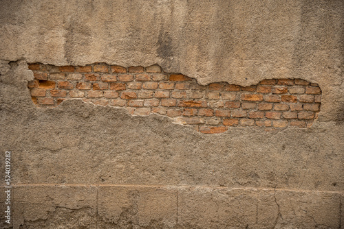 Particolare di muro vecchio con cemento rovinato e mattoni in vista photo