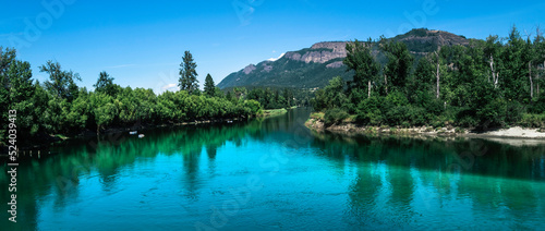 Tranquil landscape of the turquoise-colored river water and green forest at Fortune Creek park in Enderby, British Columbia, Canada
