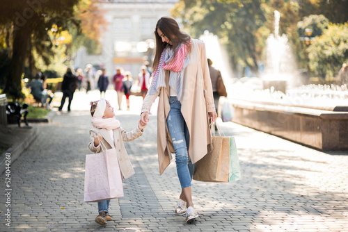 Woman with little daughter walking with shopping bags © Petro
