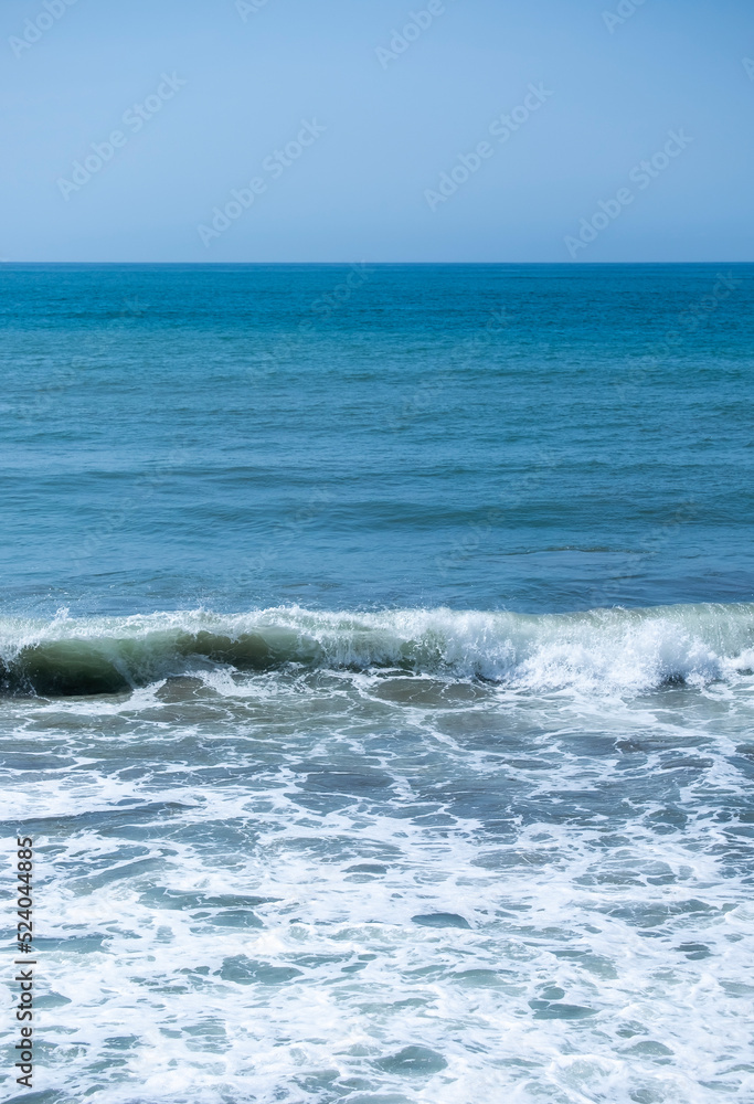 Ocean waves crashing on sandy beach. Sea waves breaking on Maditerranean's shore.