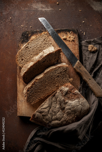 Low key food photography. Black rustic bread on dark background