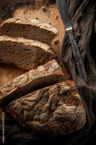 Low key food photography. Black rustic bread on dark background