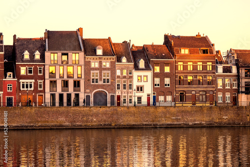 View of a beautiful sunset on the waterfront of Maastricht, the Netherlands, where the old town houses are reflected in the river Maas