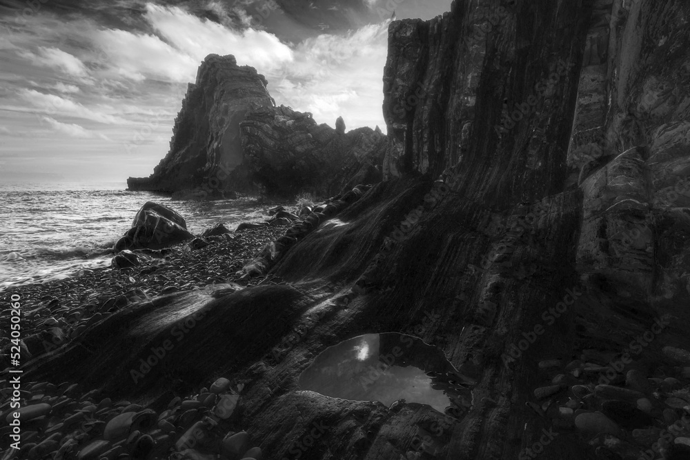 Rocky beach on the Devon coast. Black and white seascape featuring rock formation. Rocky beach on the Devon coast. Black and white seascape featuring rock formation.
