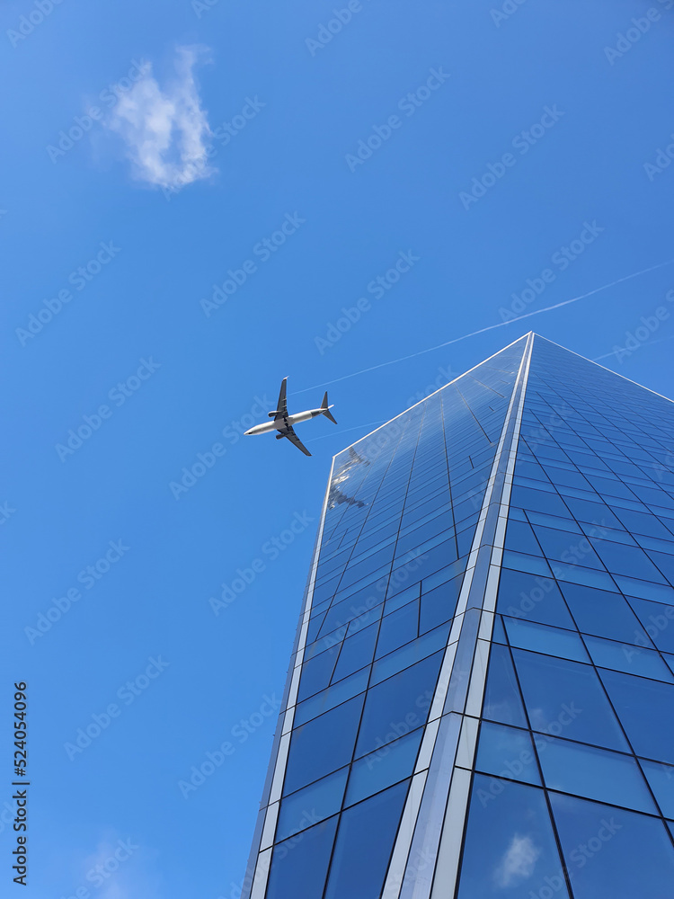 Obraz premium Airplane and office building with blue sky