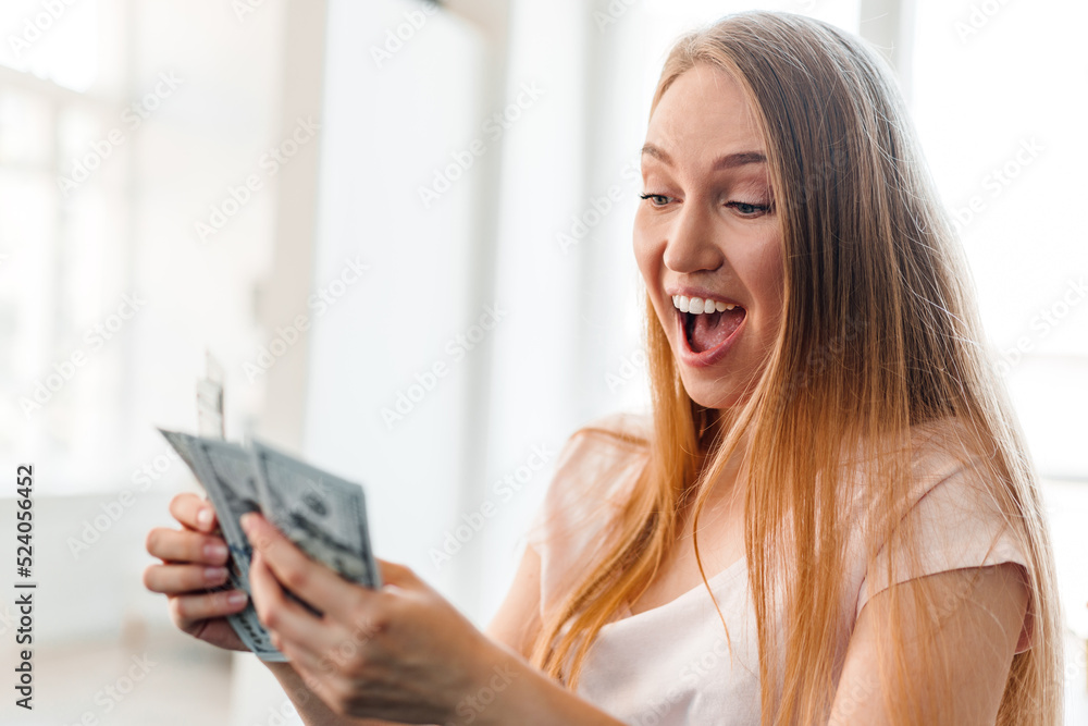 Blonde long-haired woman counting money at home Blonde long-haired woman counting money at home