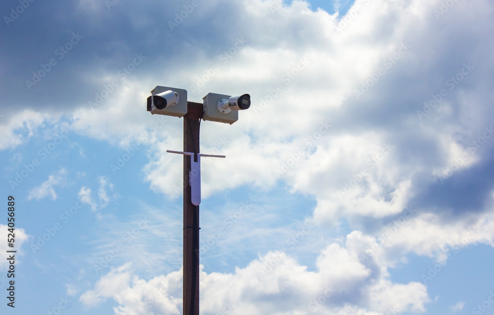 Security cameras over blue sky outdoor. Professional surveillance camera. CCTV on the pole. Security system, technology concept. Video equipment for safety system area control outdoor Security cameras over blue sky outdoor. Professional surveillance camera. CCTV on the pole. Security system, technology concept. Video equipment for safety system area control outdoor