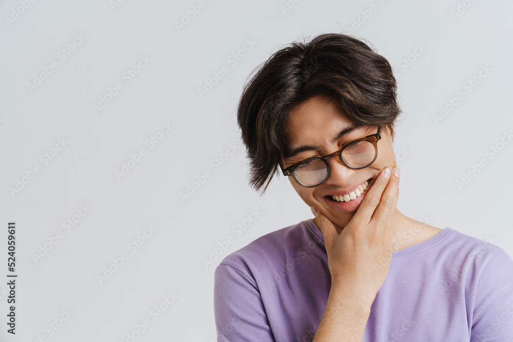 Young handsome smiling asian boy in glasses with closed eyes Young handsome smiling asian boy in glasses with closed eyes