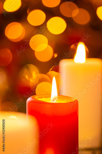 Close up shot of burning red and white candles. Gorgeous bokeh, Christmas background with copy space