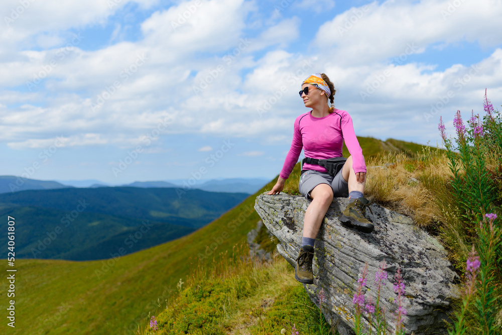 A young woman is enjoying the beauty of the Ukrainian Carpathians against the background of a mountain landscape