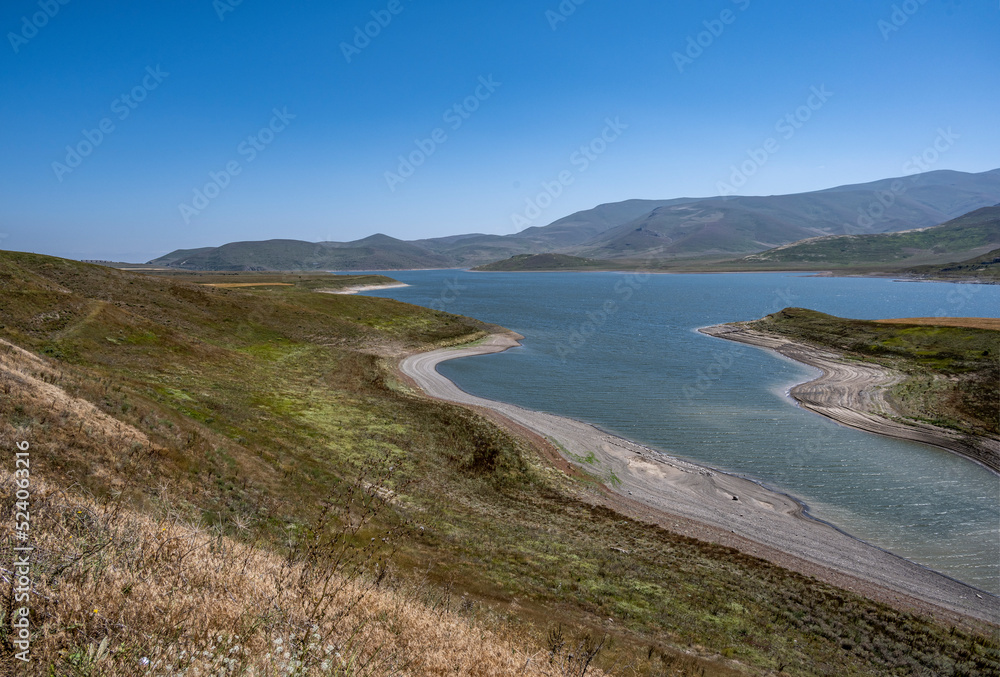 landscape with an alpine blue lake against the backdrop of mountains and blue sky in the mountains of Armenia