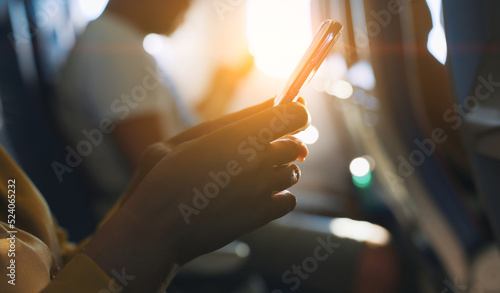 Woman using smartphone inside the airplane.