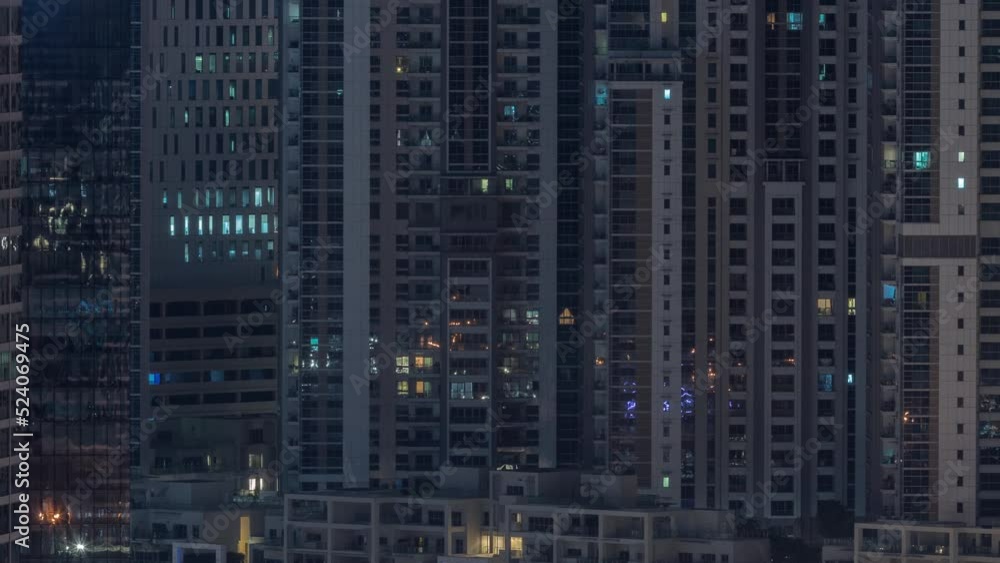 Big glowing windows in modern office and residential buildings timelapse at night, in rows of windows light shines. Traffic on the street Big glowing windows in modern office and residential buildings timelapse at night, in rows of windows light shines. Traffic on the street