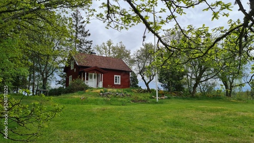 Beautiful wooden cottage surrounded by trees in Smaland, Sweden photo