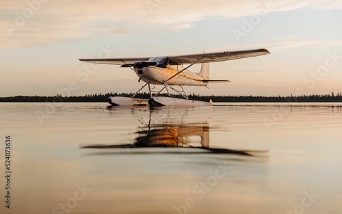 Valokuva Seaplane floats on a lake at sunset, reflected in the calm waters of Candle Lake