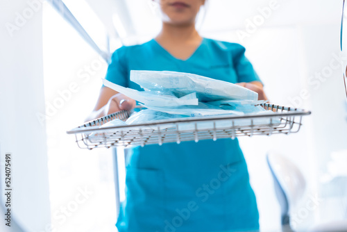 Crop anonymous dentist sterilizing tools in autoclave photo