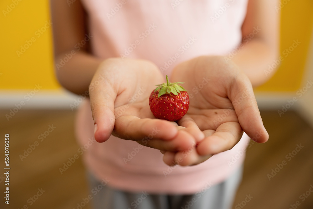 Anonymous child showing fresh strawberry Anonymous child showing fresh strawberry