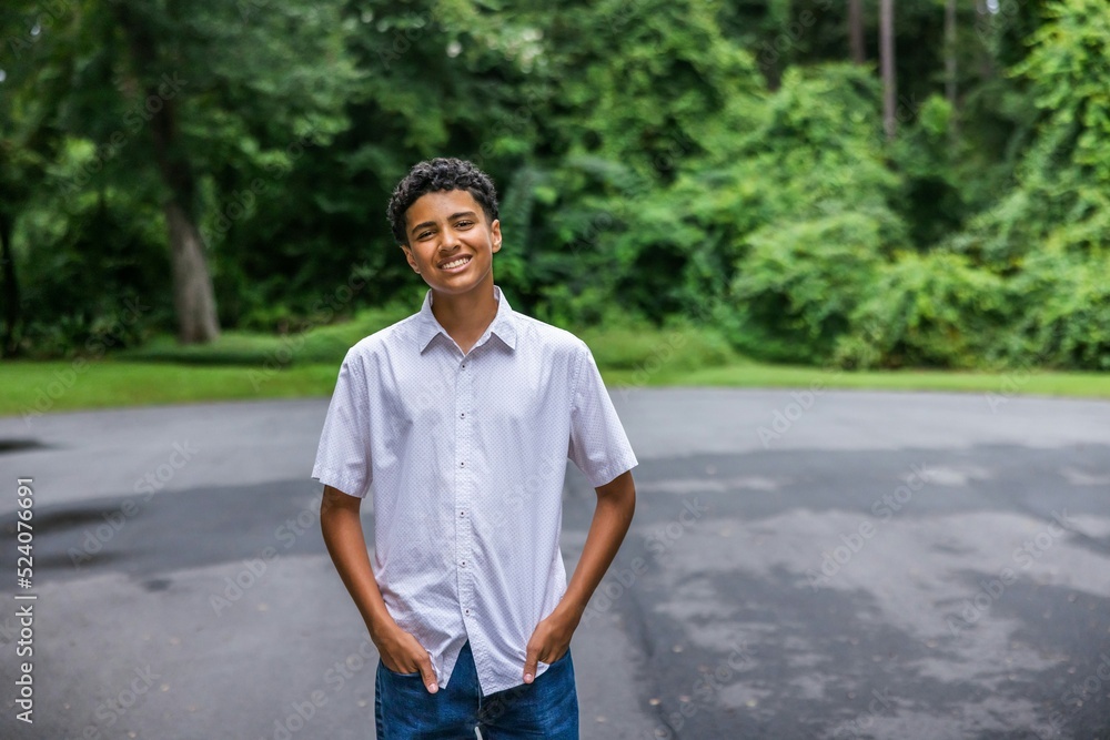 A handsome teenage guy with his hands in his pockets from the waist up with copy space A handsome teenage guy with his hands in his pockets from the waist up with copy space