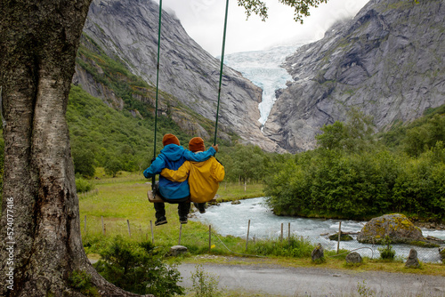 Child, cute blond boy, toddler enjoying the amazing view of glacier in Jostedalsbreen national park photo