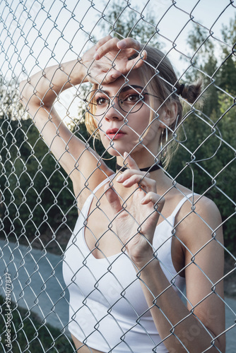 A young girl behind a mesh fence.