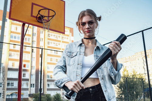 A girl with a baseball bat in her hands.