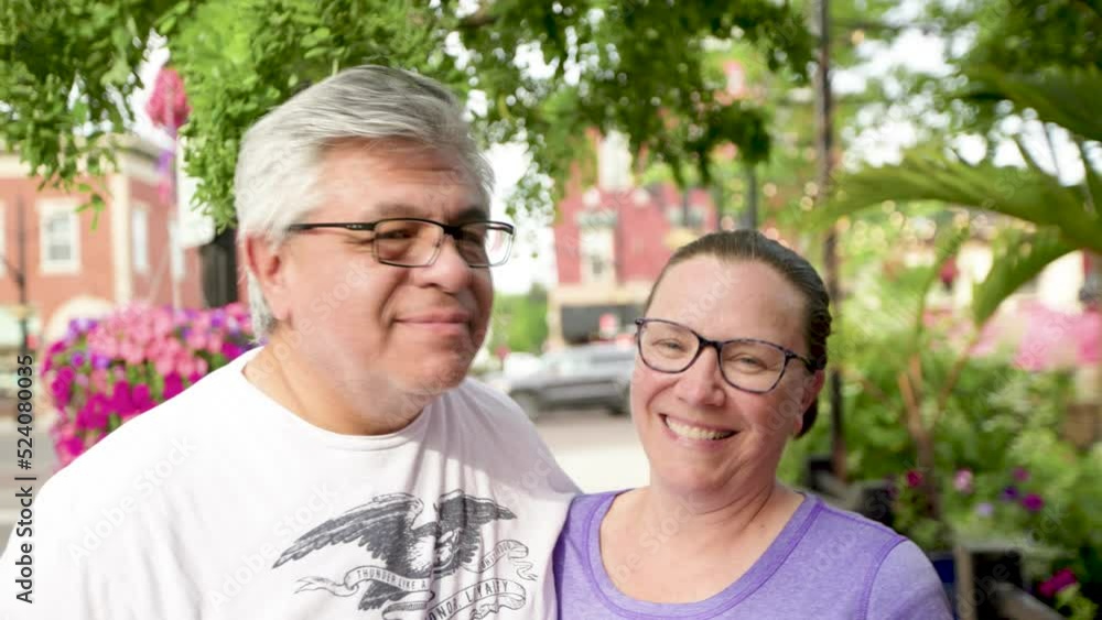 Loving couple kissing with big smiles outside while wearing glasses on a summer day in slow motion. Loving couple kissing with big smiles outside while wearing glasses on a summer day in slow motion.