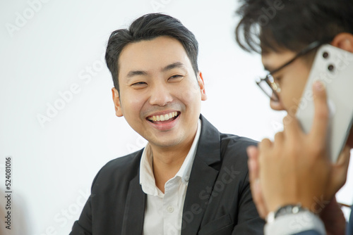 Portrait of a smiling businessman. Positive young office worker smiling with co-worker in foreground.
