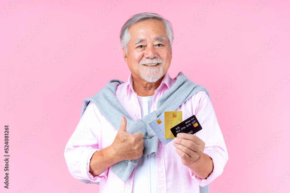retired asian elderly man with hat broken arm wear arm splint for treatment and smiling and holding credit card for confident lifestyle. retired asian elderly man with hat broken arm wear arm splint for treatment and smiling and holding credit card for confident lifestyle.